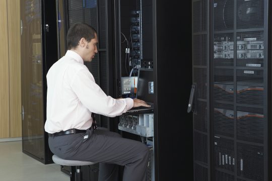 Young network engineer working in server room
